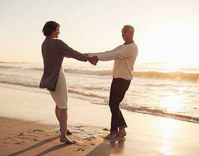 Happy Couple Holding Hands on Beach Retirement Income Strategies San Diego CA
