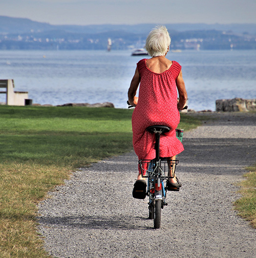 Senior Woman Riding Bike by Waterfront What is an IUL san diego CA